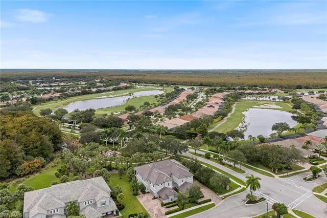 an aerial view of ocean and residential houses with outdoor space