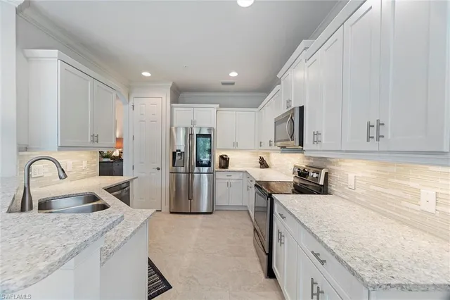 a kitchen with a sink a counter top space stainless steel appliances and cabinets