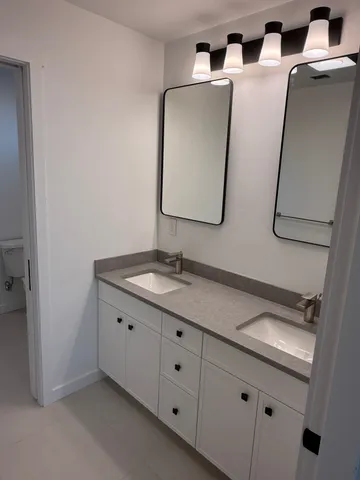 a bathroom with a granite countertop sink and a mirror