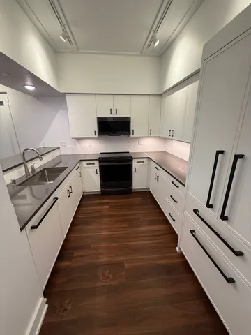 a large kitchen with stainless steel appliances granite countertop a sink and cabinets