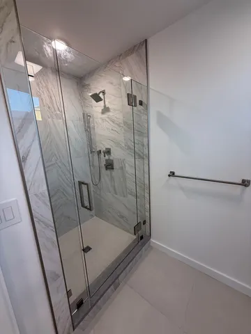 a bathroom with a shower and a glass door