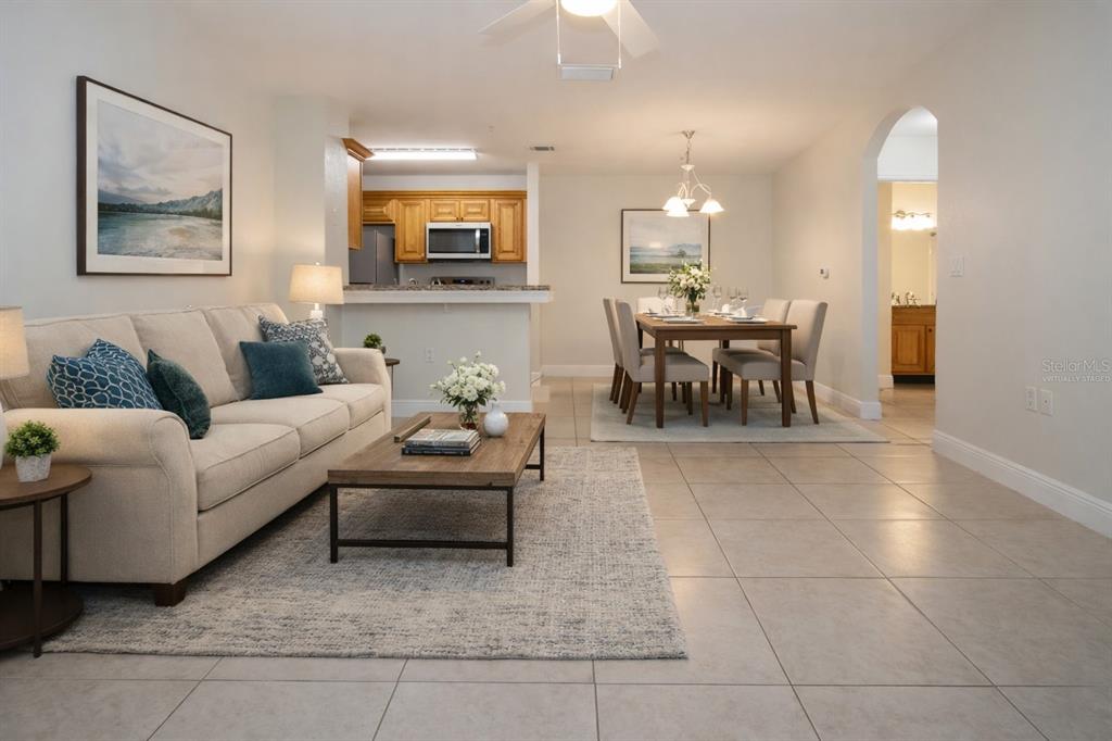 8926 Manor Loop, Unit 107 Lakewood Ranch, FL 34202 - Photo 28 of 44 a living room with furniture and a dining table with kitchen view