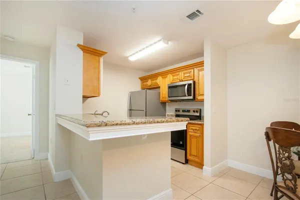 a kitchen with stainless steel appliances granite countertop a refrigerator and a stove