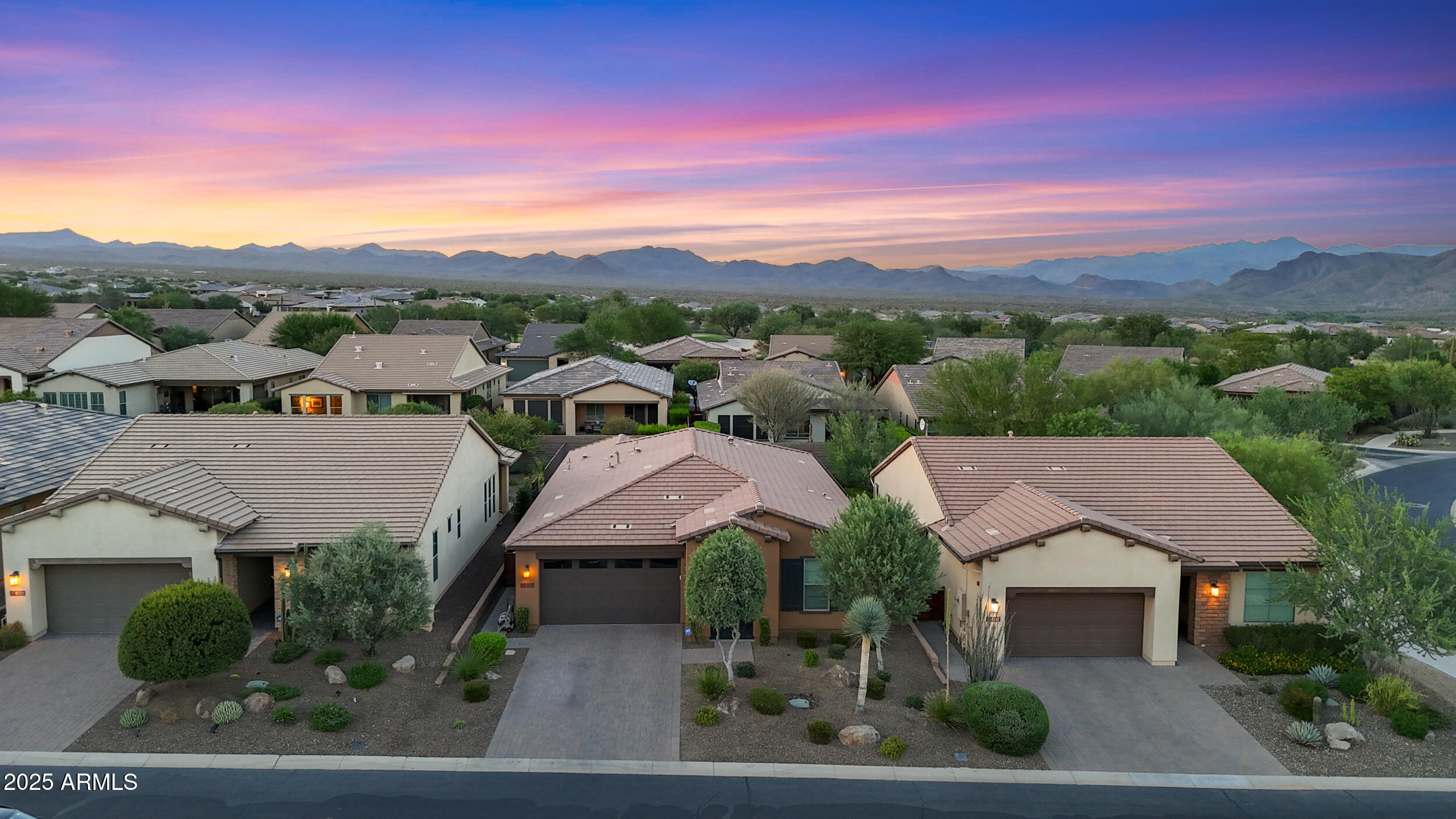 an aerial view of residential houses with outdoor space and trees