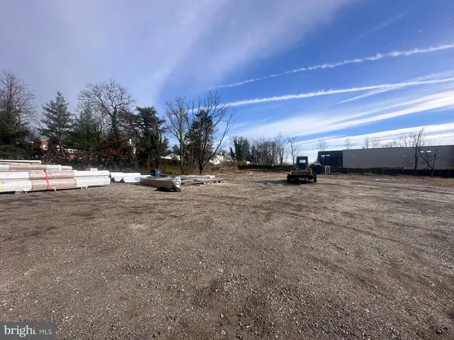 a view of a dirt road with a building in the background