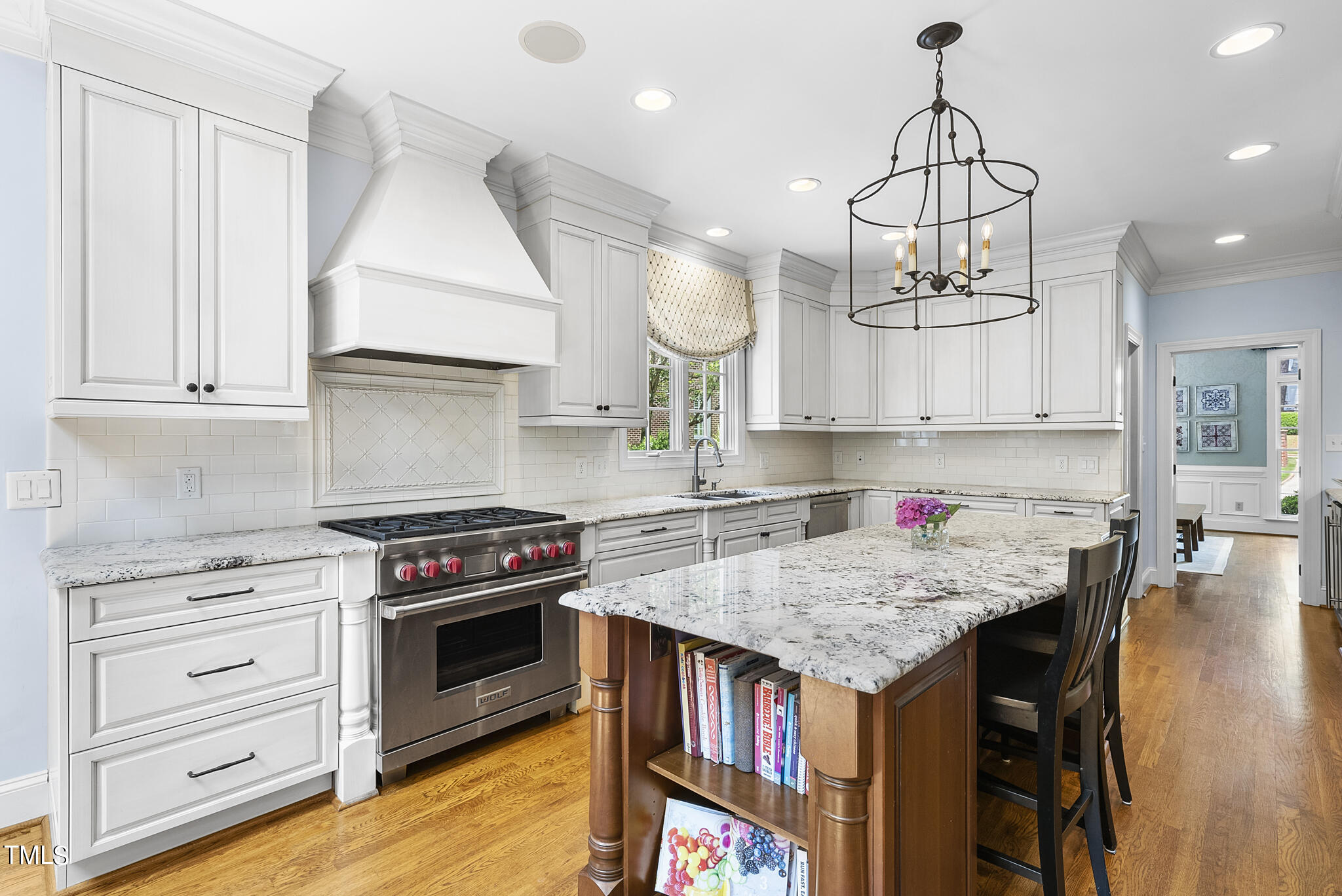 513 Lake Boone Trail Raleigh, NC 27608 - Photo 4 of 41 a kitchen with a stove a chandelier and wooden cabinets