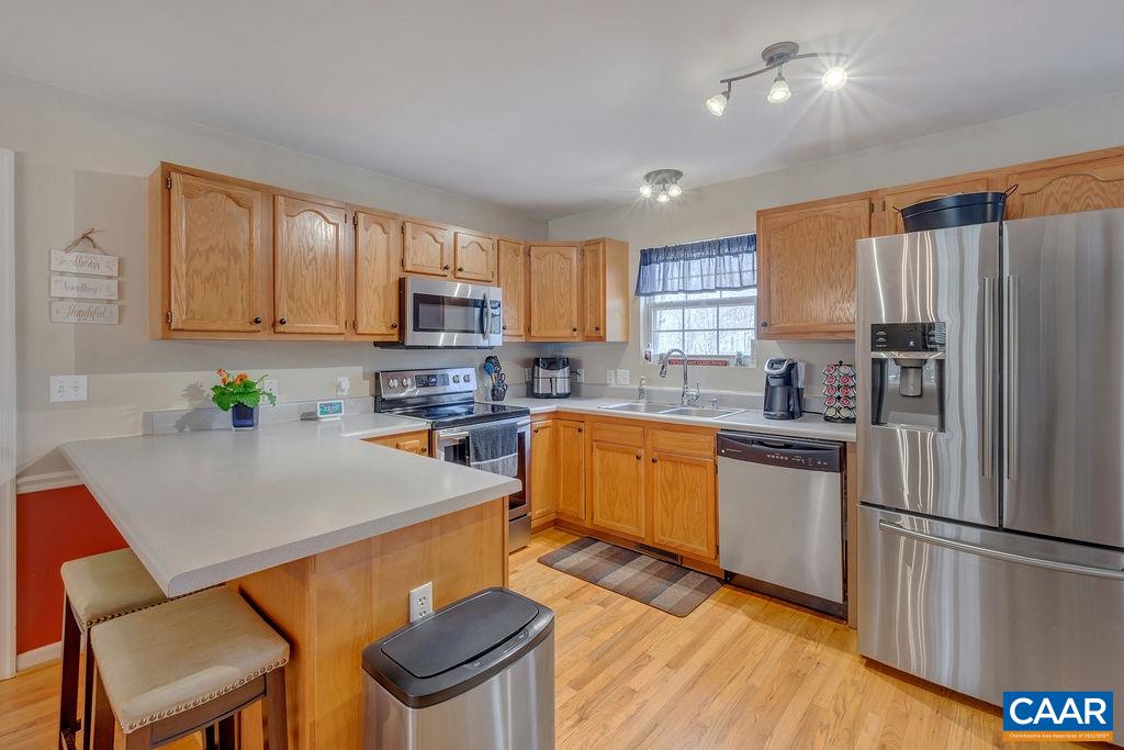 13 Stonewall Road Palmyra, VA 22963 - Photo 11 of 45 a kitchen with stainless steel appliances granite countertop a refrigerator a stove top oven a sink dishwasher and white cabinets with wooden floor