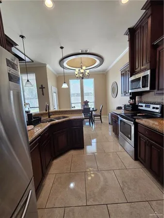 a kitchen with stainless steel appliances granite countertop a stove a sink and a refrigerator