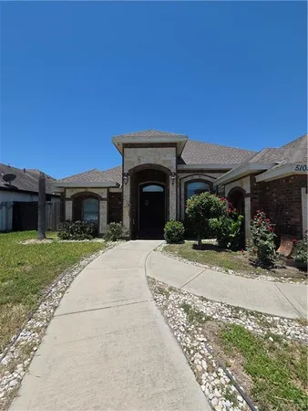 a front view of a house with a garden and yard