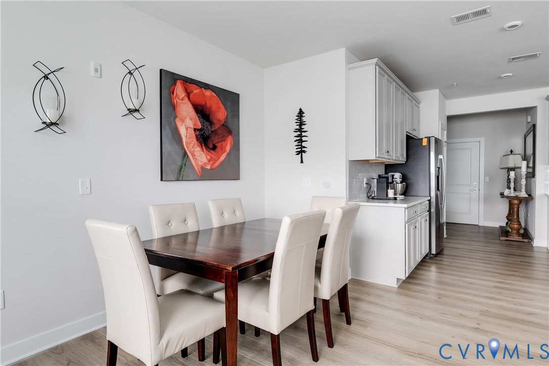 3900 Maze Runner Drive, Unit 206 Midlothian, VA 23112 - Photo 13 of 26 a view of a dining room with furniture wooden floor and a kitchen