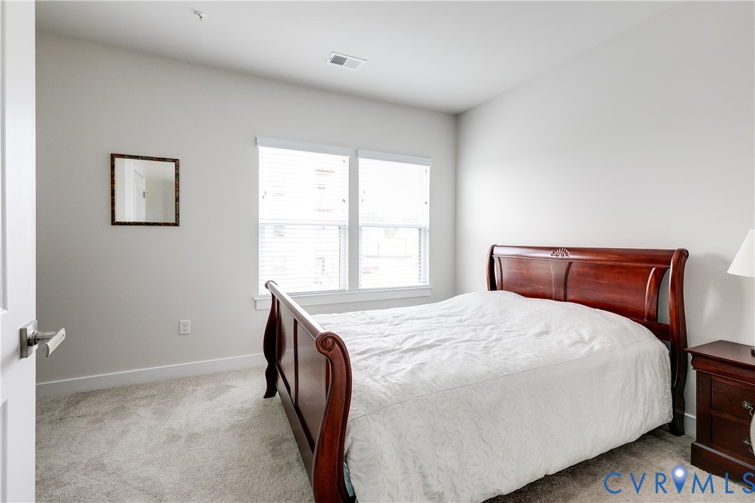 3900 Maze Runner Drive, Unit 206 Midlothian, VA 23112 - Photo 18 of 26 a bed sitting in a bedroom next to a window