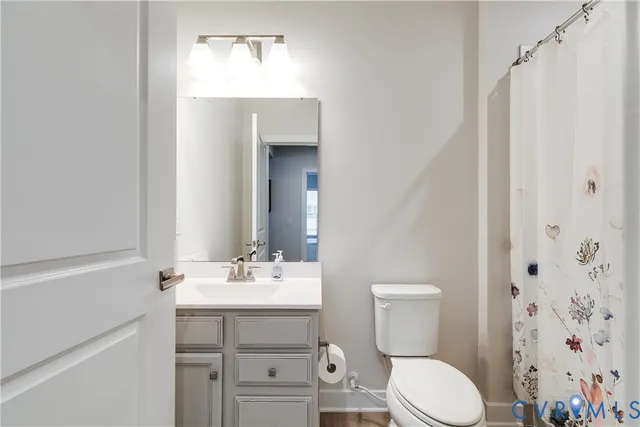 a bathroom with a sink a toilet and shower curtain