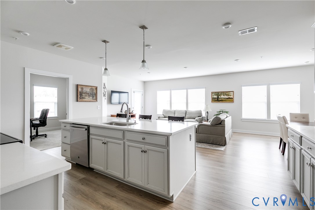 3900 Maze Runner Drive, Unit 206 Midlothian, VA 23112 - Photo 2 of 26 a large kitchen with cabinets a sink dishwasher a dining table and chairs with wooden floor