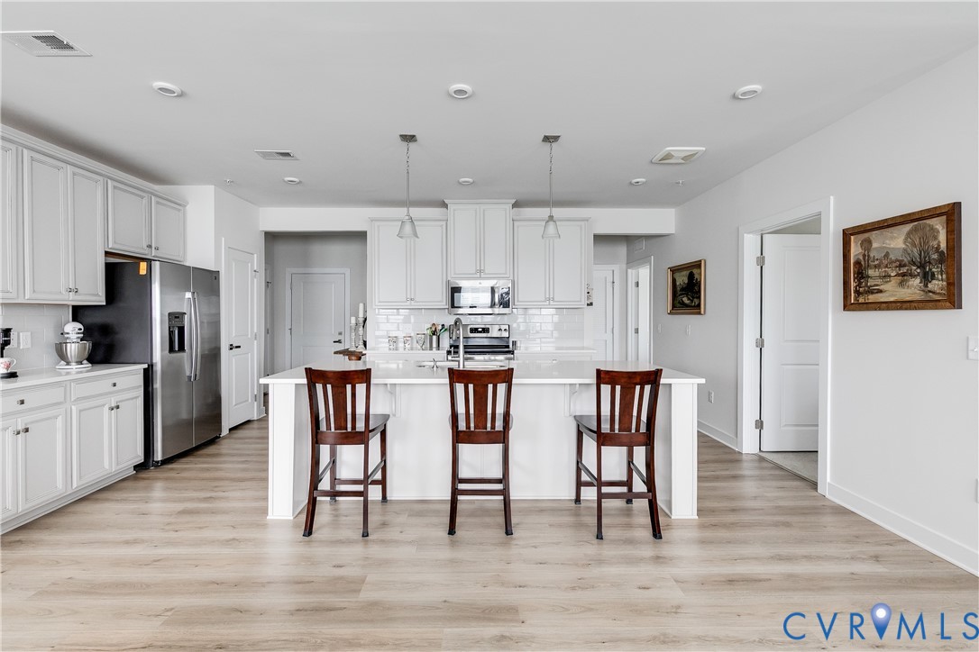 3900 Maze Runner Drive, Unit 206 Midlothian, VA 23112 - Photo 9 of 26 a kitchen with stainless steel appliances granite countertop a dining table chairs refrigerator and microwave