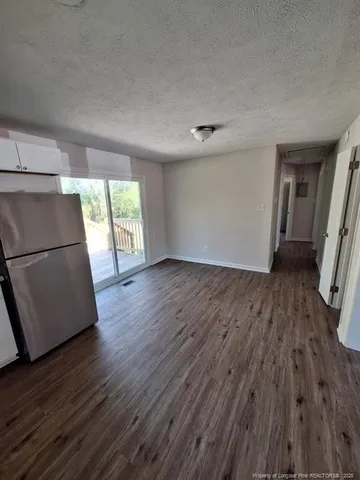 an empty room with wooden floor and a window