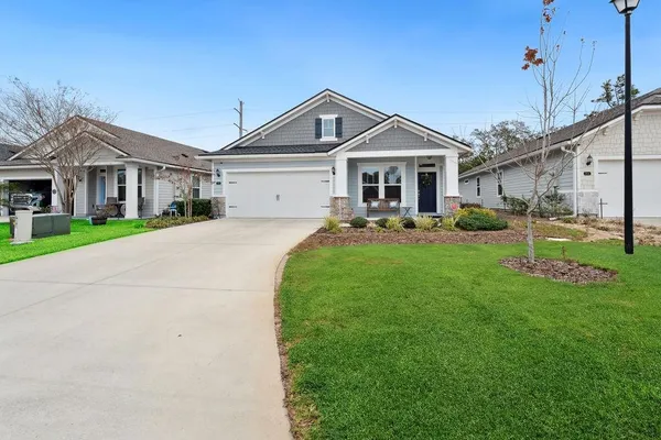 a front view of a house with a yard and trees