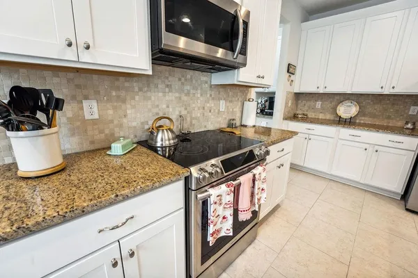 a kitchen with stainless steel appliances granite countertop a sink stove and cabinets