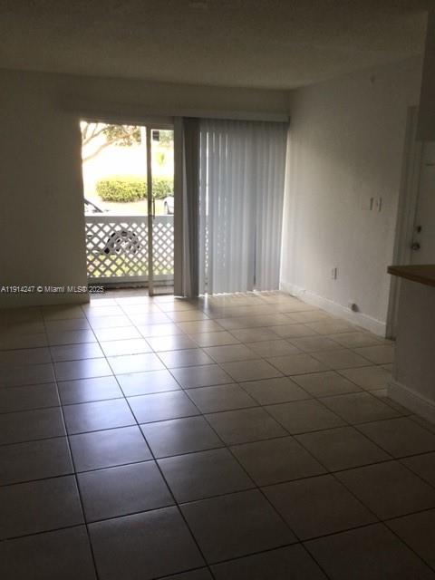 17580 Northwest 67th Place, Unit F1 Hialeah, FL 33015 - Photo 11 of 14 a view of an empty room with a stove and a window