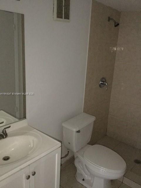 17580 Northwest 67th Place, Unit F1 Hialeah, FL 33015 - Photo 13 of 14 a white toilet sitting next to a bathroom sink