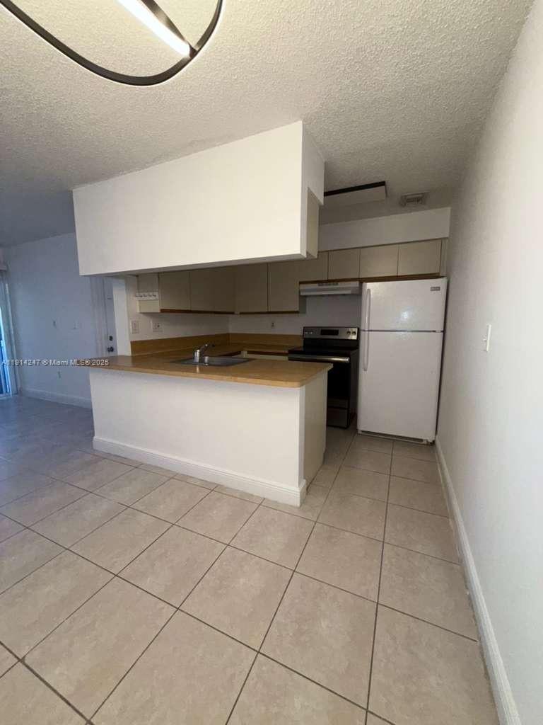 17580 Northwest 67th Place, Unit F1 Hialeah, FL 33015 - Photo 4 of 14 a kitchen with a cabinets and steel appliances