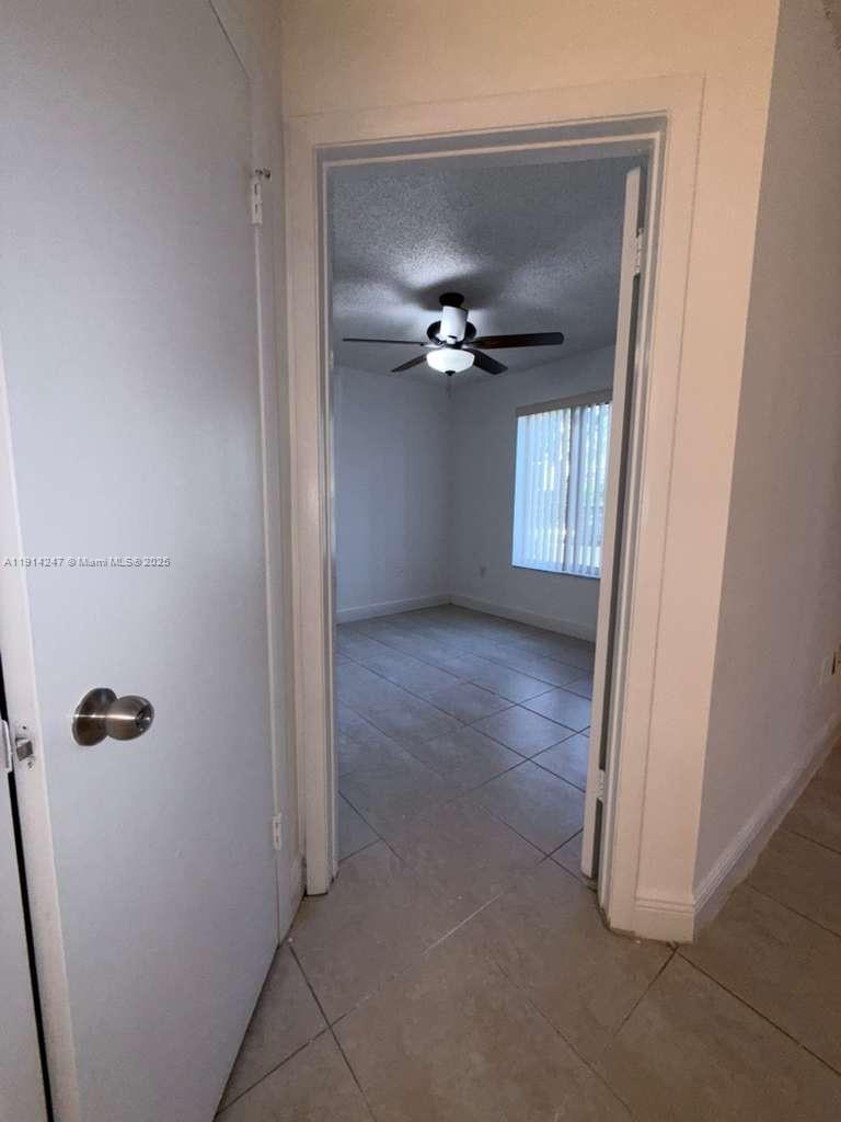 17580 Northwest 67th Place, Unit F1 Hialeah, FL 33015 - Photo 5 of 14 a view of a hallway with windows and chandelier