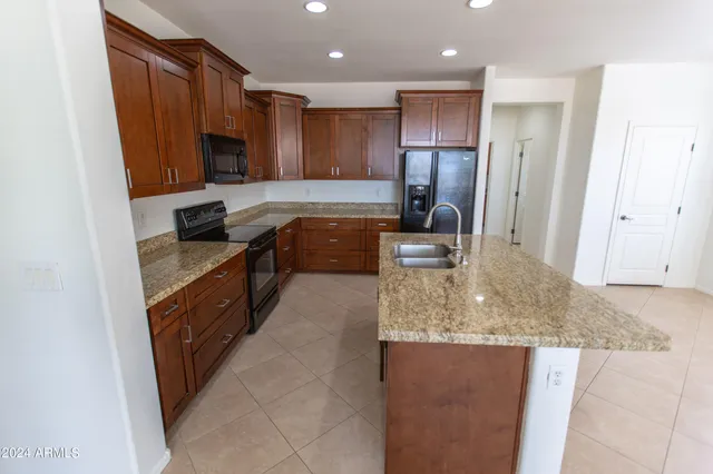 a kitchen with granite countertop a sink and cabinets