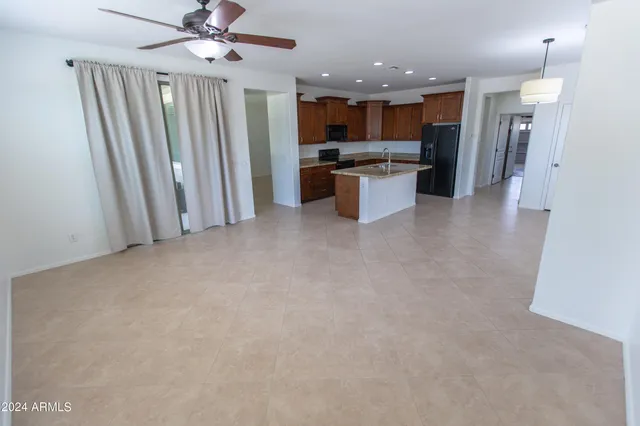 an empty room with windows and ceiling fan