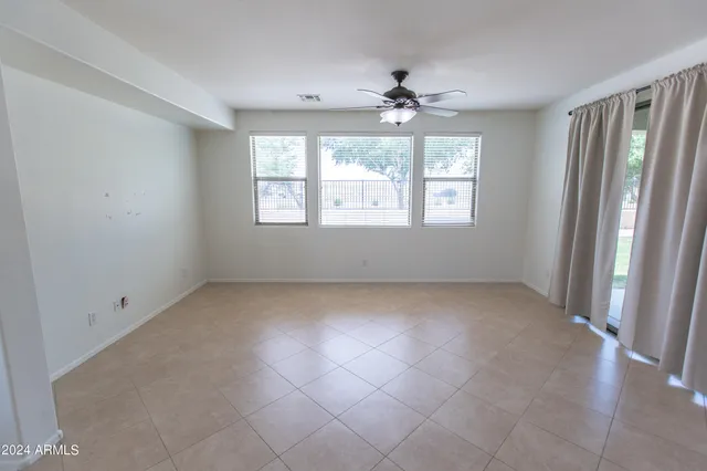 an empty room with a ceiling fan and a window