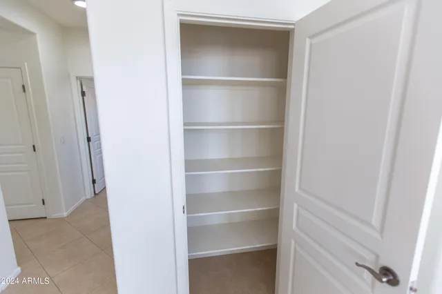 an empty room with windows and chandelier fan