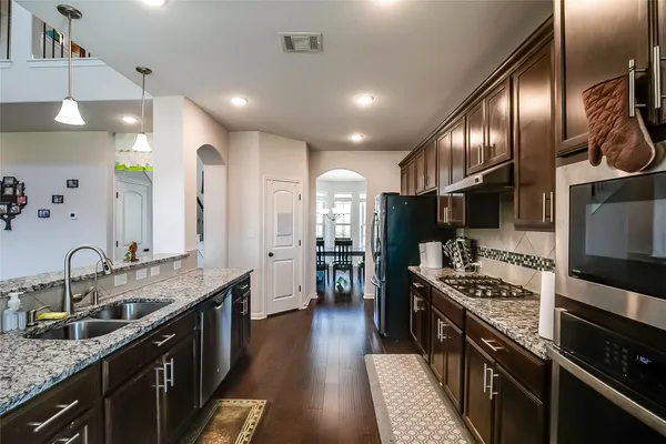 a kitchen with stainless steel appliances granite countertop a sink stove and refrigerator