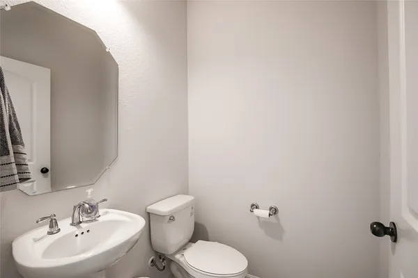 a bathroom with a sink mirror and toilet