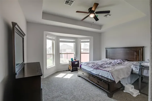 a bedroom with a bed a window and a chandelier