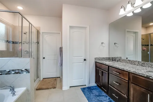 a spacious bathroom with a granite countertop sink a mirror and shower