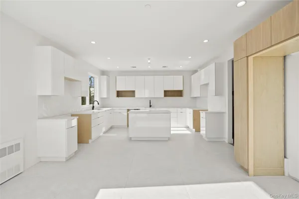 a large white kitchen with cabinets and stainless steel appliances