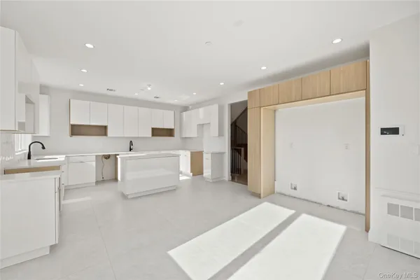 a large white kitchen with white cabinets and stainless steel appliances