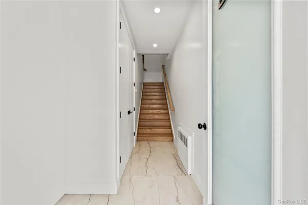 a view of a hallway with wooden floor and staircase