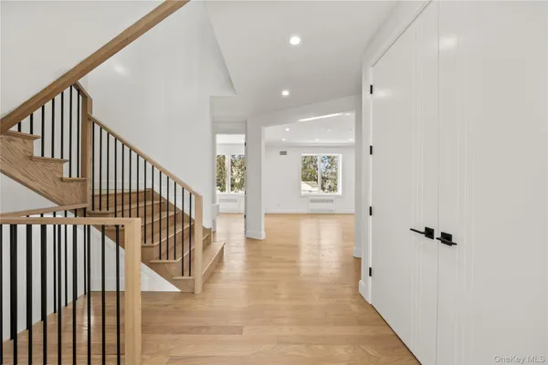 a view of a hallway with wooden floor and staircase