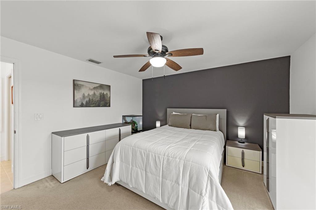 13541 Stringfellow Road Bokeelia, FL 33922 - Photo 21 of 49 a bedroom with a bed and a chandelier