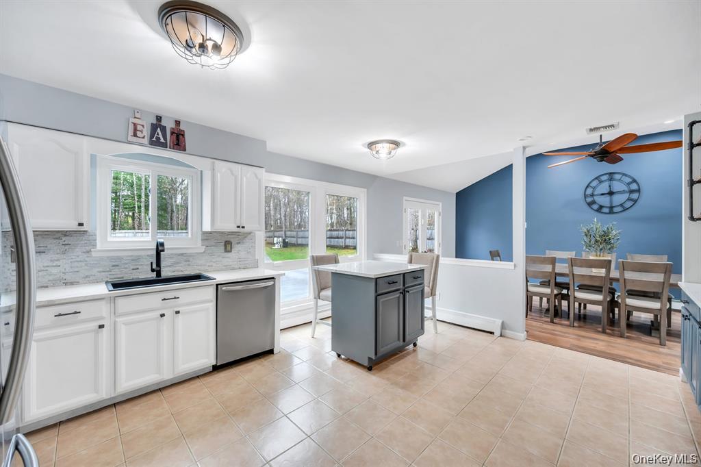 10 Ramblewood Road Ridge, NY 11961 - Photo 18 of 39 a large kitchen with kitchen island a large counter space a sink a window and stainless steel appliances