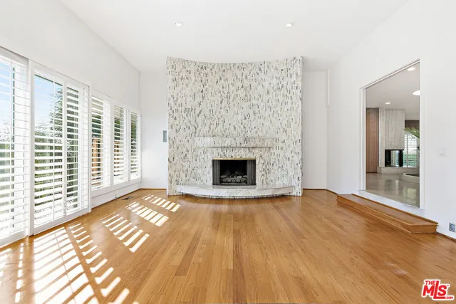 a view of empty room with wooden floor and fireplace