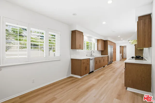 a large kitchen with stainless steel appliances granite countertop a lot of counter space and wooden floors