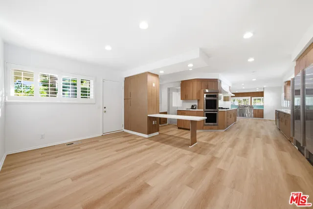 a large white room with granite countertop white cabinets and a window