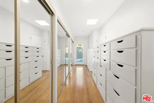 a view of a white house with a small yard and potted plants