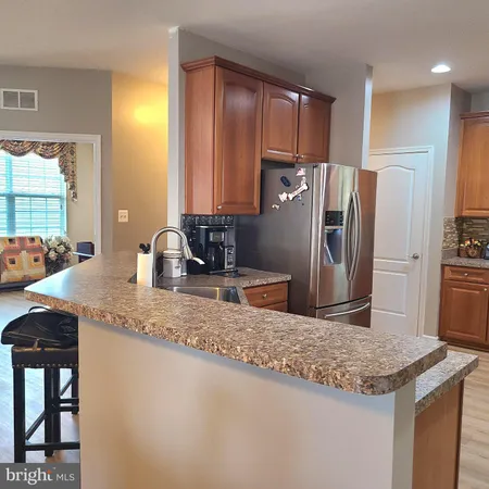 a kitchen with stainless steel appliances granite countertop a sink a stove and a refrigerator
