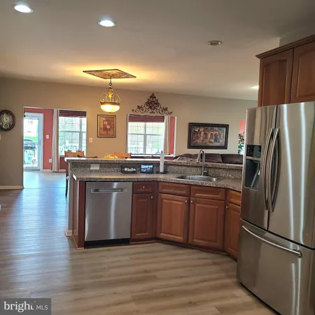 a kitchen with stainless steel appliances granite countertop a refrigerator a sink a stove and oven