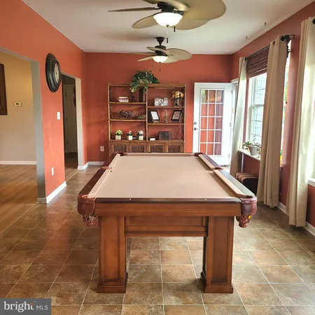 a room with pool table and windows