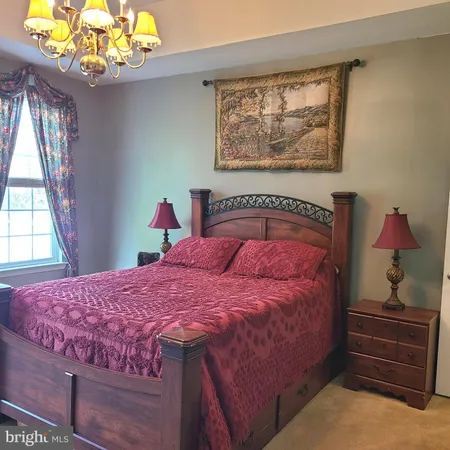 a bedroom with a bed dresser and a window