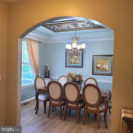a view of a dining room with furniture chandelier and wooden floor