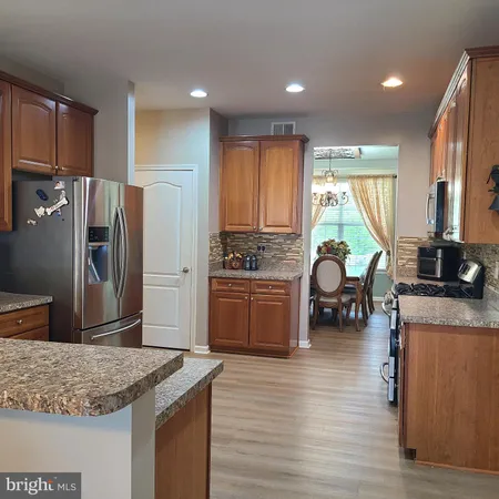 a kitchen with stainless steel appliances granite countertop a stove refrigerator sink and cabinets