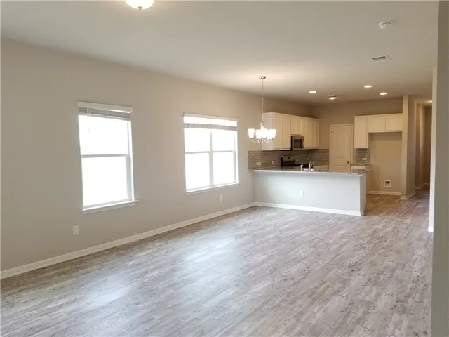 a view of a kitchen with a sink and dishwasher a oven with wooden floor
